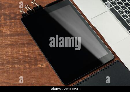 electronic gadgets and office supplies on wooden table Stock Photo