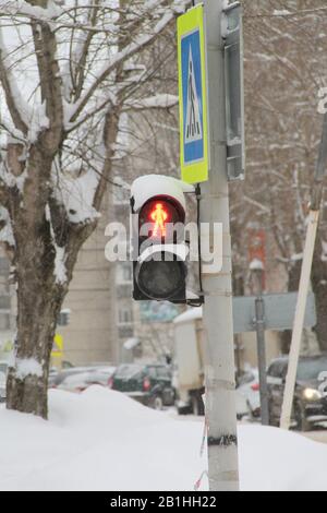 Traffic light for pedestrians with a red light in the shape of a human figure on a pillar in the city. Scenic travel background. Highway transportation concept.