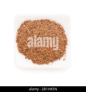 Nutmeg powder (Myristica fragrans) in a white bowl on white background. Used as a spice in many sweet as well as savoury dishes and medicine. Stock Photo