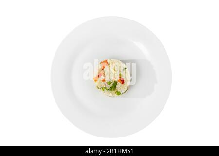 Long grain rice with vegetables, cooked portion of side dish on a plate on a white isolated background, view from above. Appetizing dish for the menu Stock Photo