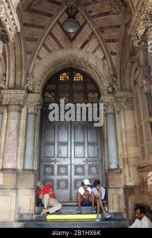 8 Sept 2019, Mumbai, Maharashtra, India. People sitting  Chhatrapati Shivaji Maharaj Terminus or Victoria Terminus train station Stock Photo