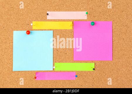 Cork board with several colorful blank notes with pins Stock Photo