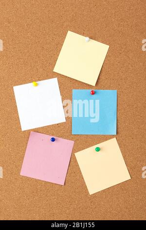 Cork board with several colorful blank notes with pins Stock Photo