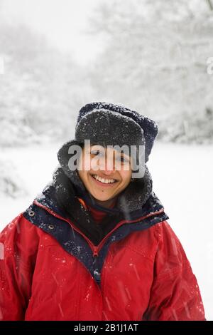 Indian woman in snow covered woods in England, UK Stock Photo