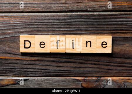 Define word written on wood block. Define text on wooden table for your desing, concept. Stock Photo