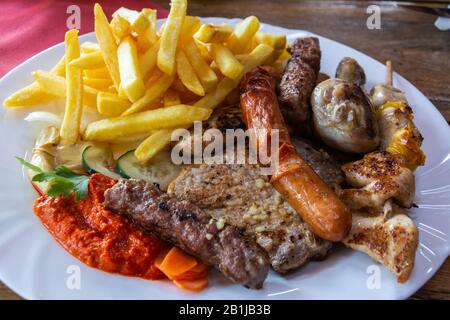 Mixed grill platter with grilled meat and sausages in Slovenia. Stock Photo