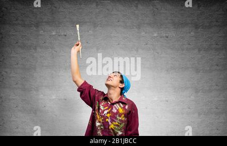 Young painter artist pointing upwards Stock Photo