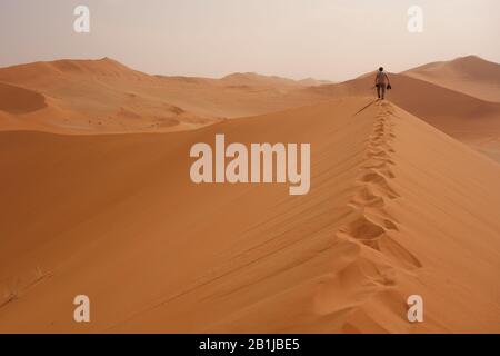 Tourist walking on red sand dune Stock Photo - Alamy