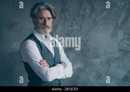 Turned photo of elegant gorgeous old millionaire man cross hands look good copy space wear modern clothes isolated over concrete wall grey color Stock Photo