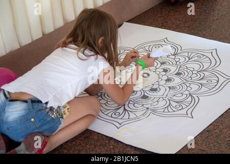 Girl creating a mandala by means of color sand. Religion Stock Photo