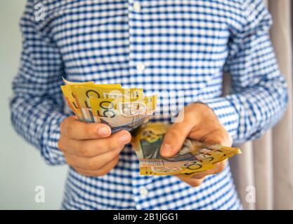 In this photo illustration a man holds Australian fifty dollar notes. Stock Photo