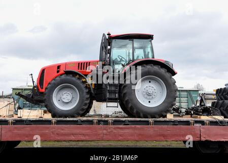 Minsk, Feb 18, 2020: New farm tractors “Belarus' by Minsk Tractor Works loaded on a freight train and delivered by rail from factory in the customs co Stock Photo