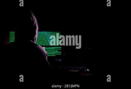 Women hacker breaks into government data servers and Infects Their System with a Virus at his hideout place has dark blue atmosphere Stock Photo