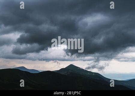 Amazing flowing rainy clouds in evening mountains. Beautiful nature of Carpathians. Landscape photography Stock Photo