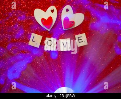 wooden carved hearts on a glittery background with blue light flash Stock Photo
