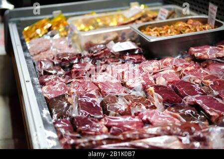 Beef, veal, lamb fresh raw steaks are packaged in vacuum and sold on counter of store. Stock Photo