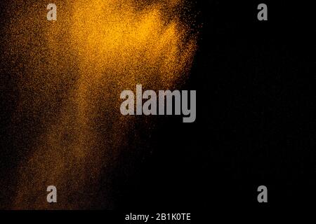 Golden sand explosion isolated on black background. Abstract sand cloud.Sandy fly wave in the air. Stock Photo
