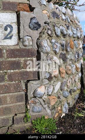 Stone and brick wall with a large vertical settlement crack. Stock Photo