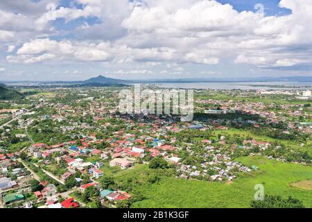 Tacloban city, Leyte island, Philippines. Tropical landscape with panorama of the town, view from above. Town and sky with cumulus clouds. Stock Photo