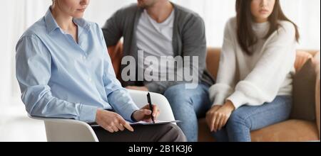 Unrecognizable Psychologist Taking Notes Working With Unhappy Couple In Office Stock Photo