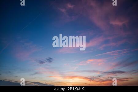 Blue sky during dawn with purple scattered clouds during a sunset Stock Photo