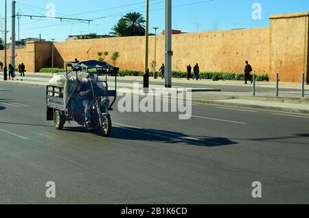 Meknes, Morocco - November 18th 2014: Unidentified biker on traditional vehicle for fast and light cargo on street along the medieval city wall Stock Photo