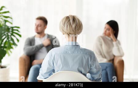 Family Counselor Talking With Couple Sitting In Office, Back View Stock Photo