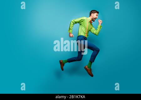 Full length body size view of nice attractive crazy energetic purposeful cheerful guy jumping running fast active isolated on bright vivid shine Stock Photo