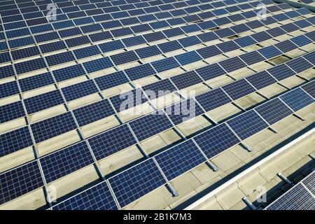 Aerial view of many photo voltaic solar panels mounted of industrial building roof. Stock Photo