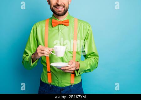 Cropped view portrait of his he nice attractive confident cheerful guy wearing festal shirt drinking hot green tea isolated on bright vivid shine Stock Photo