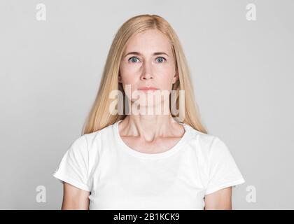 Beauty portrait of middle aged woman on grey background Stock Photo