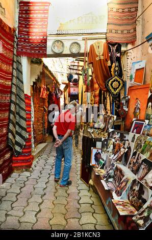 Meknes, Morocco - November 19th 2014: Unidentified people in a narrow street of the carpet souk with different shops Stock Photo