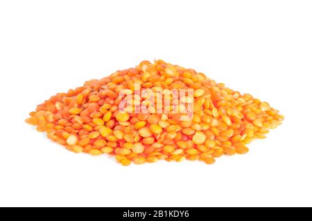 Pile Red lentils isolated on white background. Lentils are rich in protein, carbohydrates, fiber, and low in fat. Stock Photo