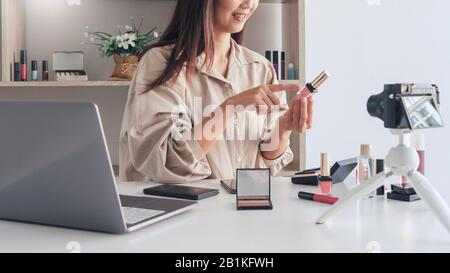 beautiful asian woman professional beauty vlog or blogger present cosmetics and applying make-up in front camera for recording video Stock Photo
