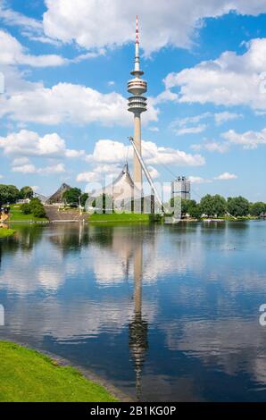 Munich, Germany – July 1, 2016. View of Olympic Tower (Olympiaturm) with reflections in  Olympiasee pond in Olympic park in Munich, Germany, on a sunn Stock Photo