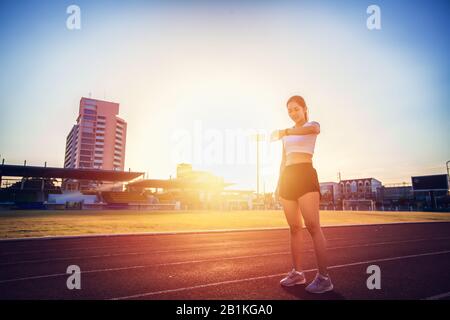 Asian woman checking her performance on watch before running Stock Photo