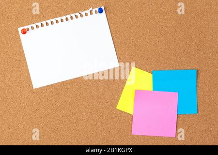 Cork board with several colorful blank notes with pins Stock Photo