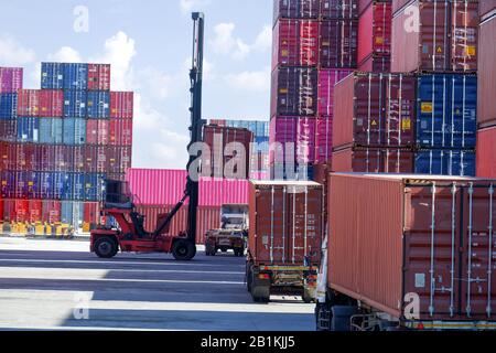 Container lifting equipment for working on boats and trucks waiting to receive goods Stock Photo