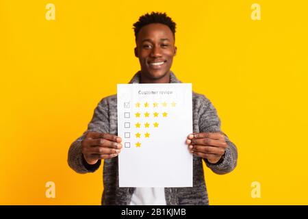 Young smiling african man is pointing on five stars rating Stock Photo