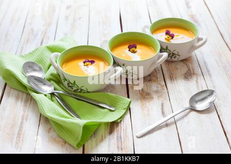 Puree soup, made from orange pumpkin, sweet potatoes and carrots, served with sour cream Stock Photo