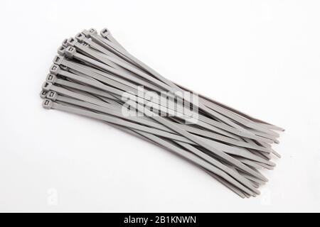 Cable tie in grey, isolated in front of white background Stock Photo