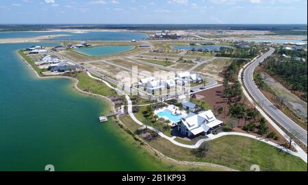 Aerial view of parts of Babcock Ranch in Florida. A community club house and recreation center with pool in the foreground by a lake. Solar powered Stock Photo