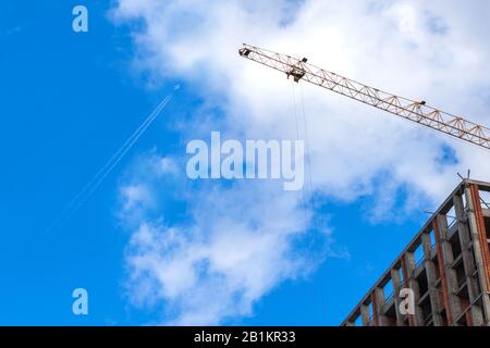 Construction of a modern residential complex. The construction of a multi-story building. cargo crane on a background of blue sky. Stock Photo