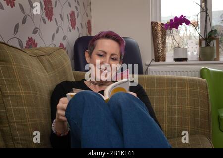 A woman reading a book about affirmations Stock Photo