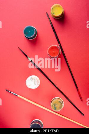 Paint brushes and paint on a red background Stock Photo