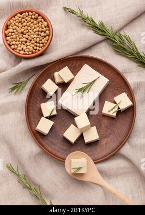 Tofu and soybeans on wooden plates with rosemary Stock Photo