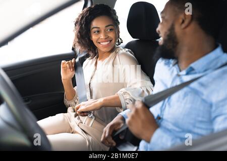 Joyful Spouses Putting On Seat Belts Sitting In New Automobile Stock Photo