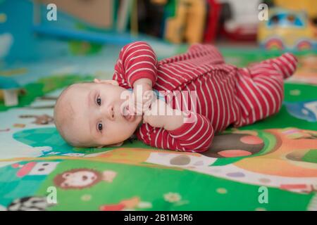 Cute little baby boy trying to roll on belly and crawling Stock Photo
