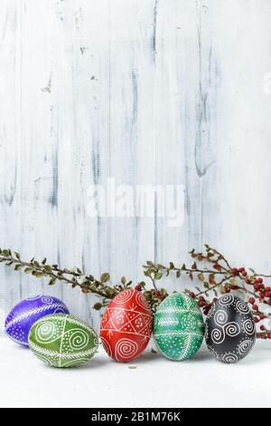 Pysanky, Ukrainian Easter eggs decorated with wax-resist dyeing technique on white wooden background Stock Photo