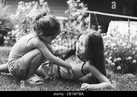 Two Happy little girls laughing and playing at the summer park. Happy Kids concept.  Black and white photo Stock Photo